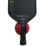 Pickleball paddle with red and black design on a light gray background